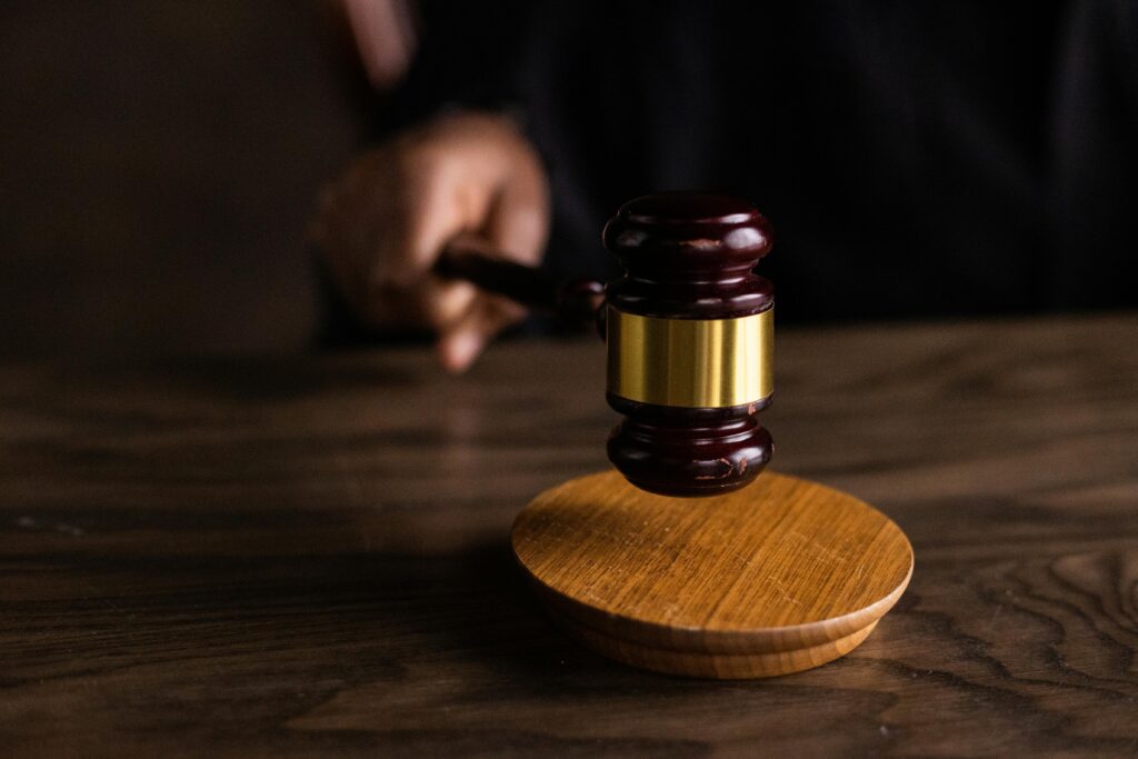 A gavel striking a sound block, symbolizing justice and legal authority in a courtroom setting.